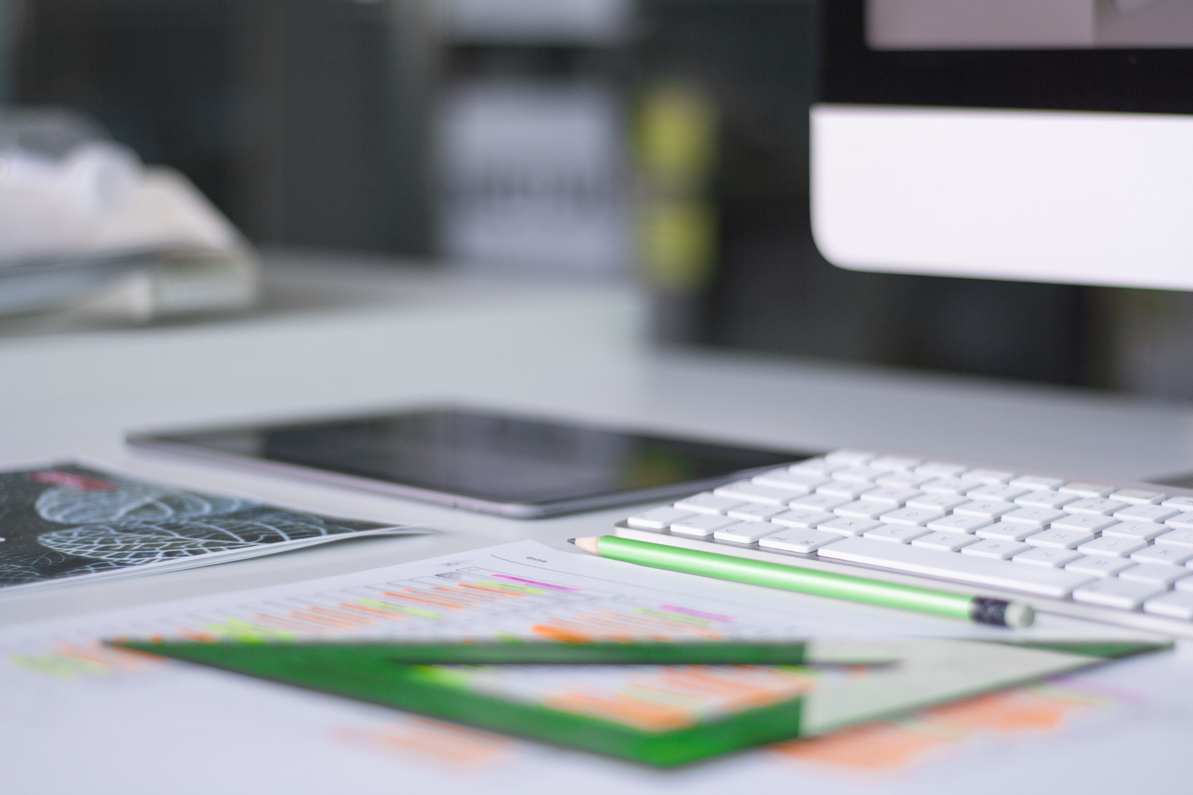 Clavier, tablette et documents annotés sur un bureau.